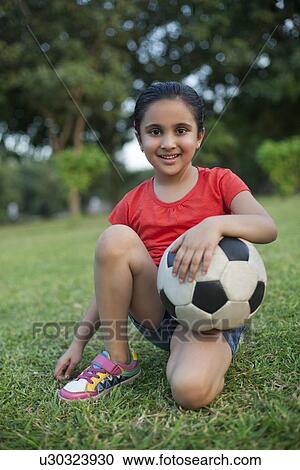 Portrait of a young girl holding a football View Large Photo Image Stock Image - Portrait of a young girl holding a football. Fotosearch