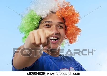 Stock Photo - Portrait of a young man cheering . Fotosearch