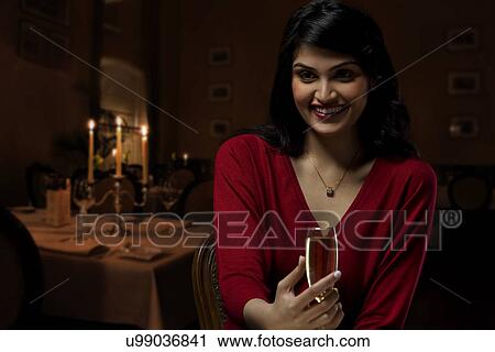 Stock Image - Portrait of a young woman with a wine glass . Fotosearch