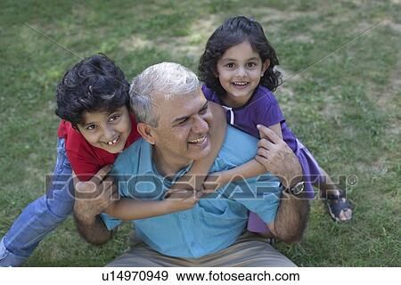 Stock Photo - Portrait of grandchildren hugging grandfather. Fotosearch