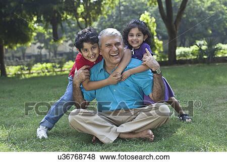 Stock Photo - Portrait of grandchildren hugging grandfather. Fotosearch