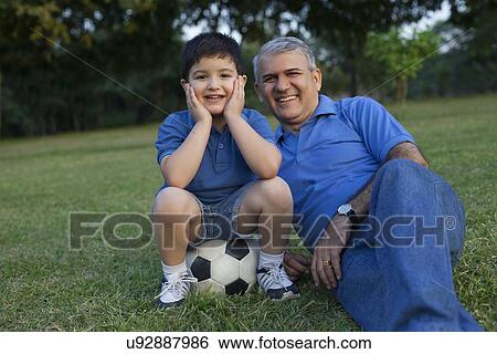 Portrait of grandfather and grandson in a park View Large Photo Image Stock Photograph - Portrait of grandfather and grandson in a park. Fotosearch