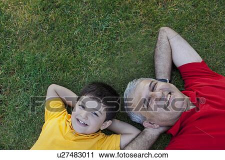 Portrait of grandfather and grandson lying in the grass View Large Photo Image Stock Image - Portrait of grandfather and grandson lying in the grass. Fotosearch
