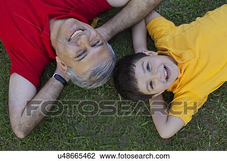Portrait of grandfather and grandson lying in the grass View Large Photo Image Stock Image - Portrait of grandfather and grandson lying in the grass. Fotosearch