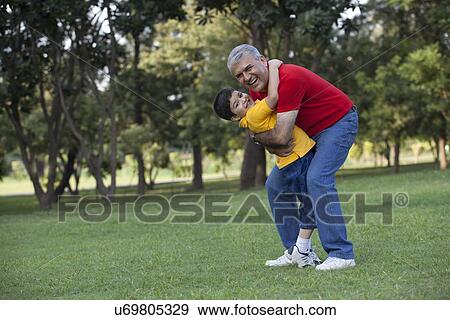 Portrait of grandfather and grandson hugging in a park View Large Photo Image Stock Photo - Portrait of grandfather and grandson hugging in a park. Fotosearch