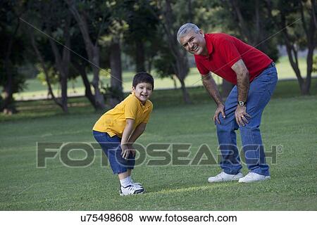 Stock Photo - Portrait of grandfather and grandson enjoying in a park. Fotosearch