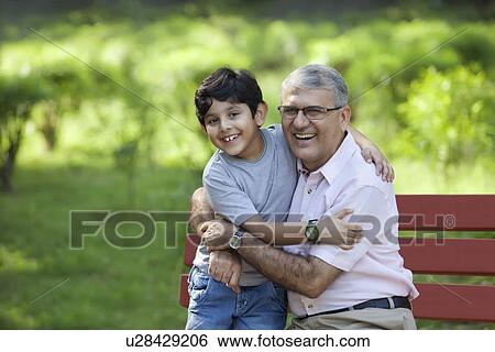 Portrait of grandfather and grandson hugging in a park View Large Photo Image Stock Photograph - Portrait of grandfather and grandson hugging in a park. Fotosearch