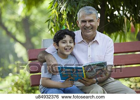 Portrait of grandfather and grandson with a book in a park View Large Photo Image Stock Photograph - Portrait of grandfather and grandson with a book in a park. Fotosearch