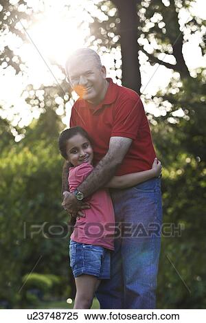 Portrait of grandfather and granddaughter hugging in a park View Large Photo Image Stock Photography - Portrait of grandfather and granddaughter hugging in a park. Fotosearch