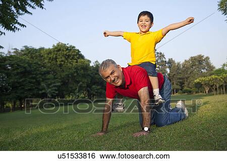 Stock Photograph - Portrait of grandfather giving grandson a piggyback ride. Fotosearch
