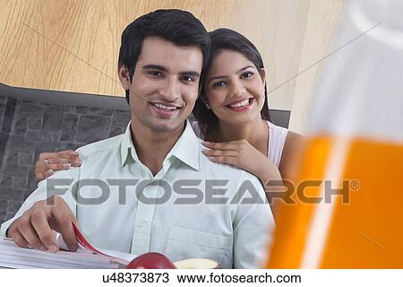 Portrait of happy couple with catalogues in kitchen View Large Photo Image Stock Image - Portrait of happy couple with catalogues in kitchen. Fotosearch