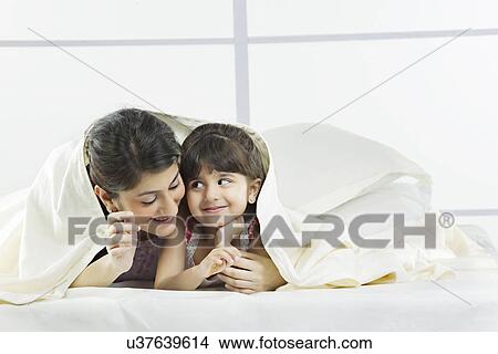 Portrait of mother and daughter covered with a bed sheet View Large Photo Image Picture - Portrait of mother and daughter covered with a bed sheet . Fotosearch