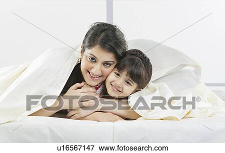 Portrait of mother and daughter covered with a bed sheet View Large Photo Image Stock Photo - Portrait of mother and daughter covered with a bed sheet . Fotosearch