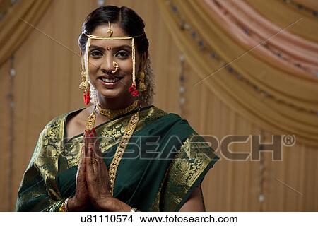 Portrait of pretty young bride greeting with hands clasped View Large Photo Image Picture - Portrait of pretty young bride greeting with hands clasped . Fotosearch