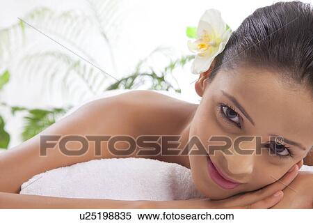 Stock Photography - Portrait of smiling woman on massage table at spa . Fotosearch