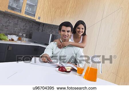 Portrait of smiling young couple in kitchen View Large Photo Image Stock Photography - Portrait of smiling young couple in kitchen. Fotosearch