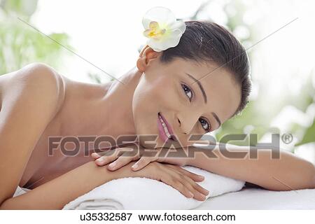 Portrait of smiling young woman lying on massage table View Large Photo Image Stock Photo - Portrait of smiling young woman lying on massage table . Fotosearch