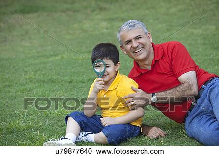 Portrait of young boy with grandfather holding magnifying glass View Large Photo Image Stock Image - Portrait of young boy with grandfather holding magnifying glass. Fotosearch