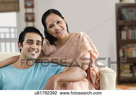 Portrait of young son and mature woman sitting on couch at home View Large Photo Image Stock Image - Portrait of young son and mature woman sitting on couch at home . Fotosearch