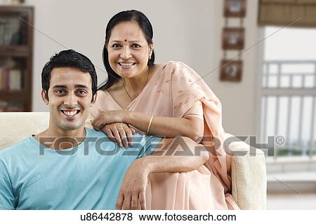 Portrait of young son and mature woman sitting on couch View Large Photo Image Stock Photo - Portrait of young son and mature woman sitting on couch . Fotosearch
