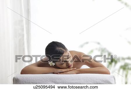 Picture - Pretty woman with eyes closed lying on message table . Fotosearch