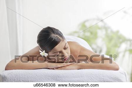 Stock Photo - Pretty woman with eyes closed lying on message table . Fotosearch