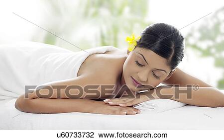 Stock Image - Pretty young woman lying on massage table . Fotosearch