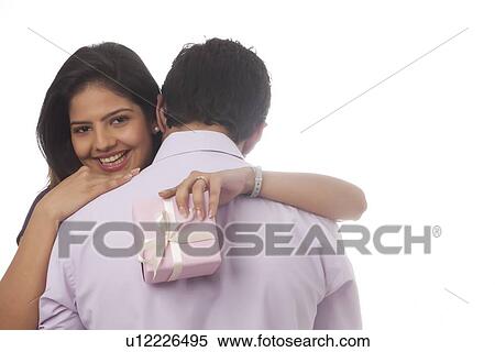 Stock Photography - Rear view of a woman with a gift hugging. Fotosearch