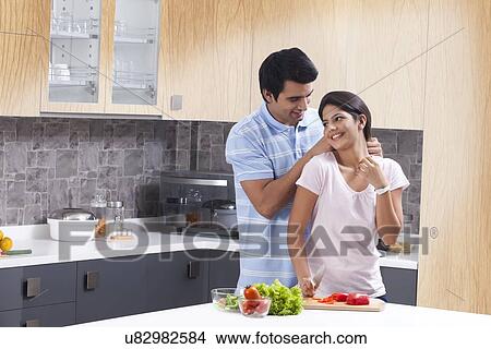 Romantic man gifting necklace to woman in kitchen View Large Photo Image Picture - Romantic man gifting necklace to woman in kitchen. Fotosearch