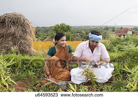 Rural man having lunch as his wife looks on View Large Photo Image Stock Image - Rural man having lunch as his wife looks on . Fotosearch