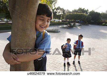 Stock Photo - School boy hugging a tree . Fotosearch
