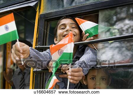 Stock Photo - School boys holding the Indian flag in a bus . Fotosearch
