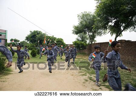 Stock Photograph - School boys running with the Indian flag . Fotosearch