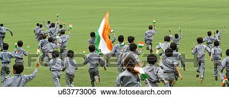 Stock Photograph - School boys running with the Indian flag . Fotosearch