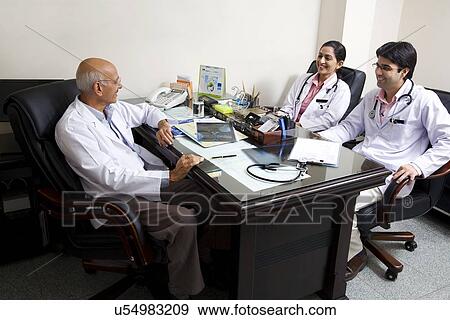 Senior doctor talking to other doctors View Large Photo Image Stock Photo - Senior doctor talking to other doctors . Fotosearch