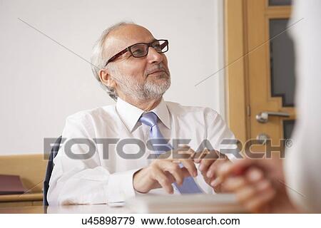 Stock Photo - Senior male business executive in a meeting. Fotosearch