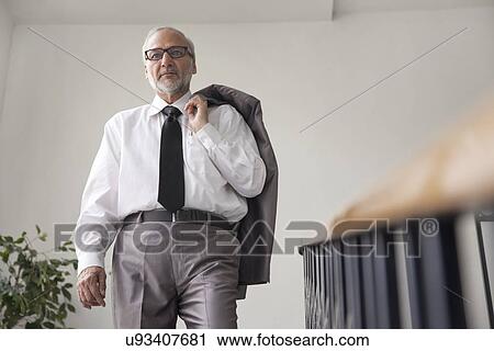 Stock Image - Senior male executive on a staircase. Fotosearch