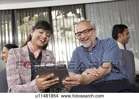 Senior man and woman looking at a tablet View Large Photo Image Picture - Senior man and woman looking at a tablet. Fotosearch