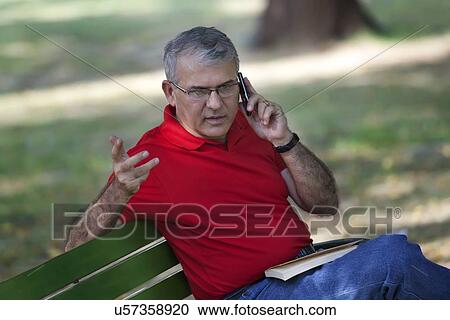 Stock Image - Senior man talking on a mobile phone. Fotosearch