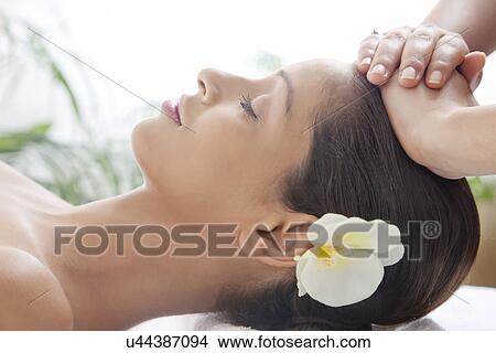 Side view of beautiful woman on massage table getting head massage View Large Photo Image Picture - Side view of beautiful woman on massage table getting head massage . Fotosearch