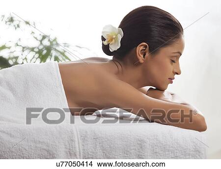 Side view of young woman lying on massage table View Large Photo Image Picture - Side view of young woman lying on massage table . Fotosearch