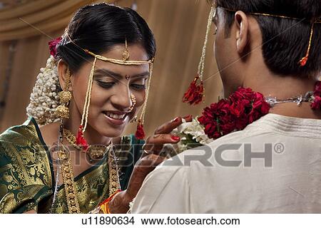 Smiling beautiful bride exchanging garland with groom View Large Photo Image Picture - Smiling beautiful bride exchanging garland with groom . Fotosearch