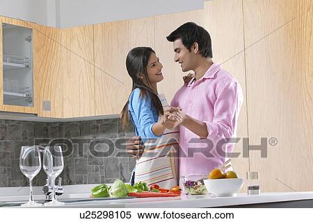 Smiling couple dancing while preparing salad in kitchen View Large Photo Image Stock Photography - Smiling couple dancing while preparing salad in kitchen. Fotosearch