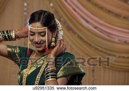 Stock Photography - Smiling Maharashtrian bride getting ready for the wedding . Fotosearch