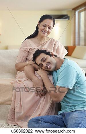 Smiling man resting on mature mother's lap View Large Photo Image Stock Image - Smiling man resting on mature mother's lap . Fotosearch