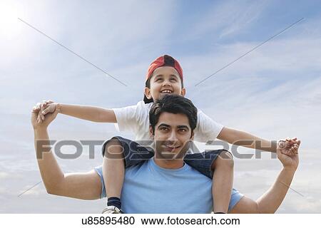 Son getting a piggyback ride from his father View Large Photo Image Stock Image - Son getting a piggyback ride from his father . Fotosearch