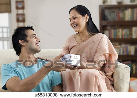 Stock Photo - Son giving gift to his mother . Fotosearch