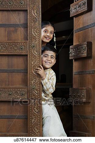 South Indian boy and girl peeping from the doorway View Large Photo Image Stock Photo - South Indian boy and girl peeping from the doorway . Fotosearch