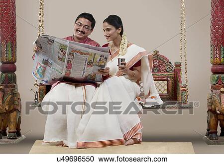 Stock Image - South Indian couple sitting on a jhula . Fotosearch