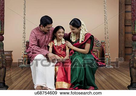 Stock Photo - South Indian family sitting on a jhula . Fotosearch